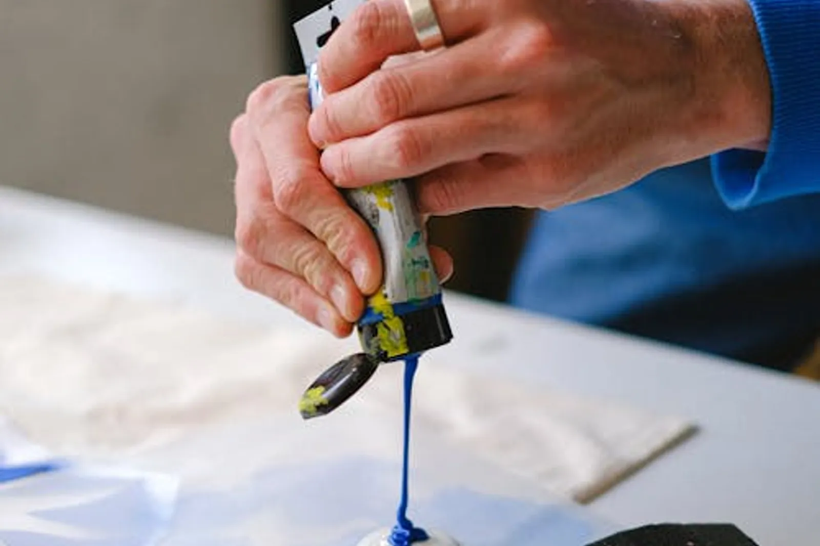 Un atelier de peinture avec tubes d’acrylique, palette colorée et toile en cours de réalisation.