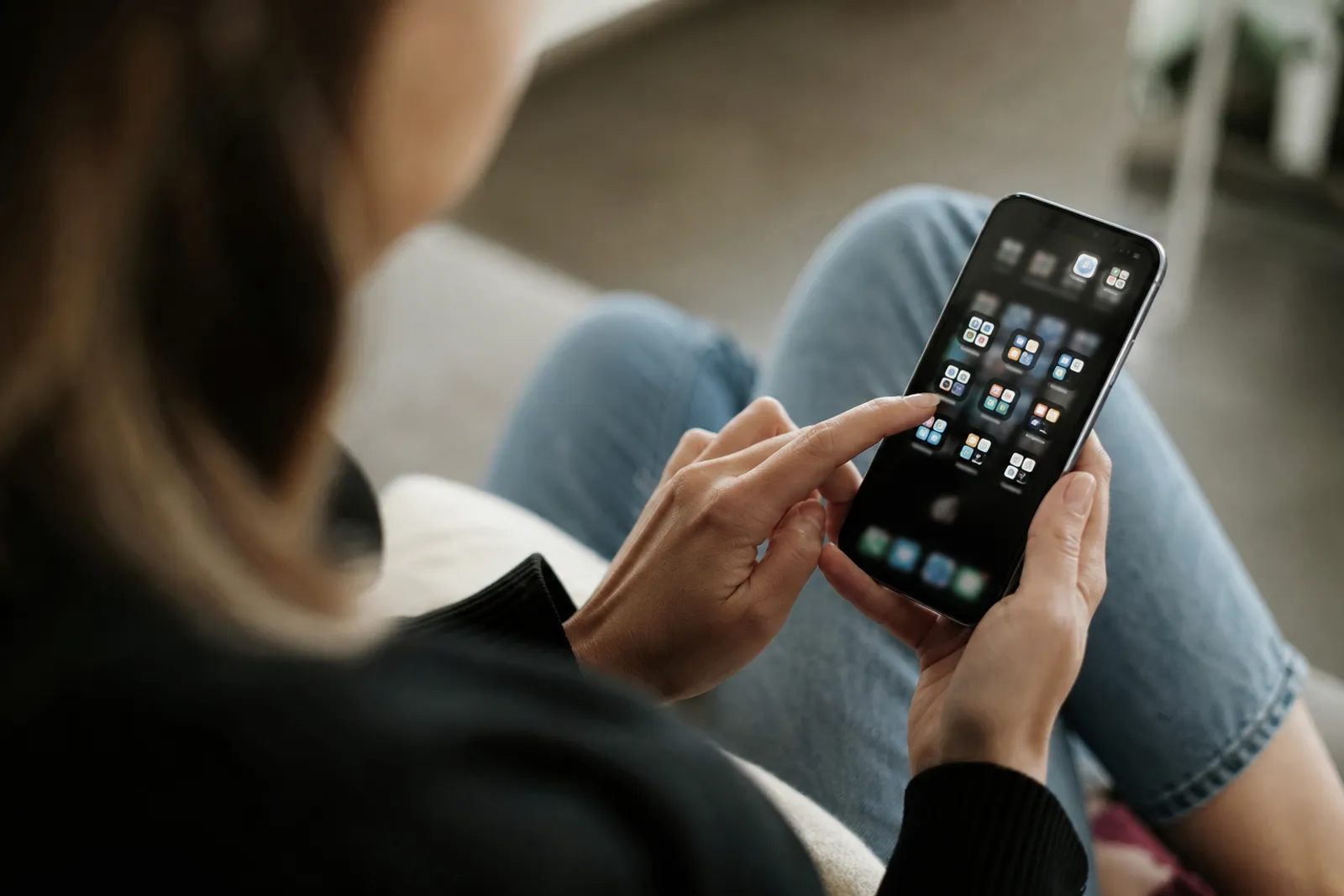 Une personne fait le tri dans les applications de son smartphone, écran visible, dans une ambiance lumineuse et calme.