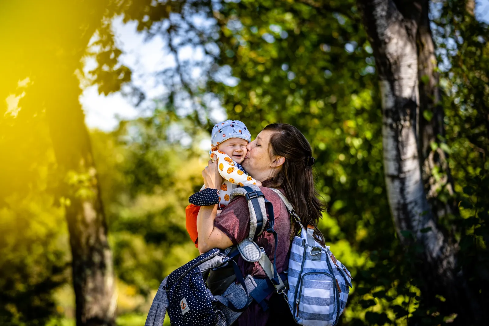 Un parent nettoie délicatement un porte-bébé à la main dans une buanderie lumineuse.